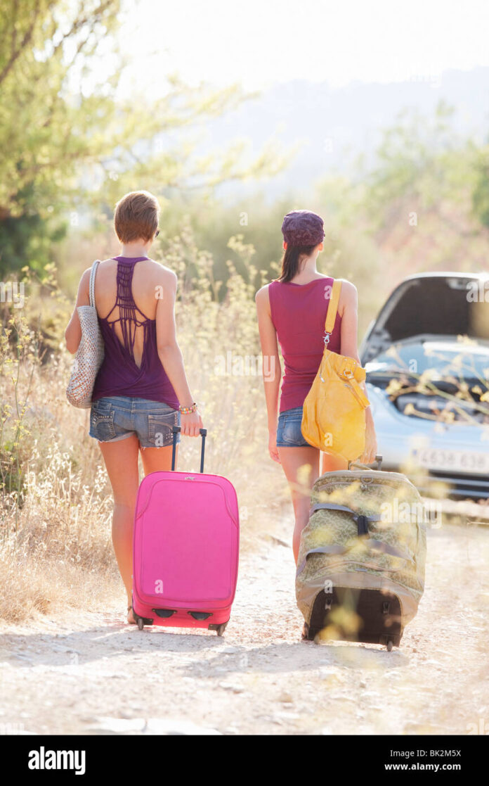 two-women-walking-to-their-car-BK2M5X